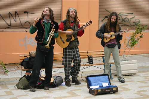 Three hippies playing guitar for money